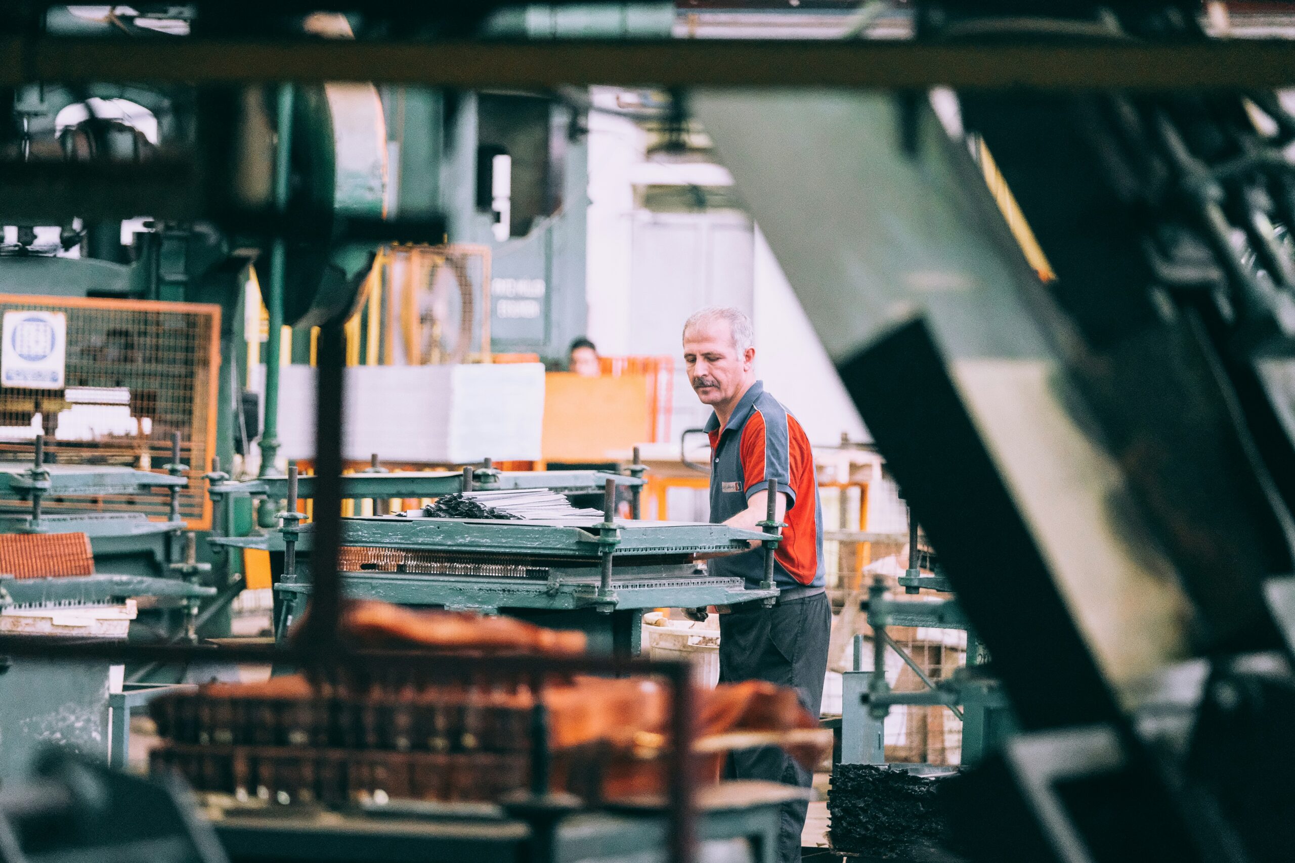 Employé d'une PME manufacturière québécoise devant une ligne de production automatisée
